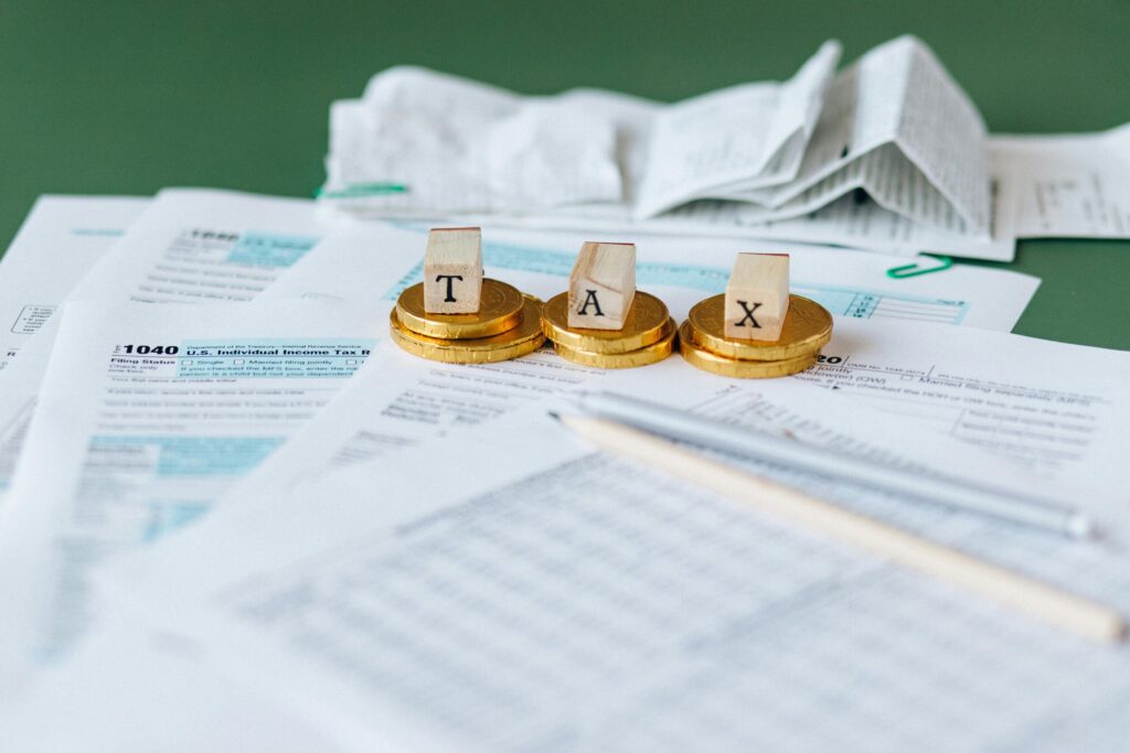 pexels-photo-6863183-6863183 Close-up of tax forms, receipts, and coins symbolizing financial accounting and taxes.